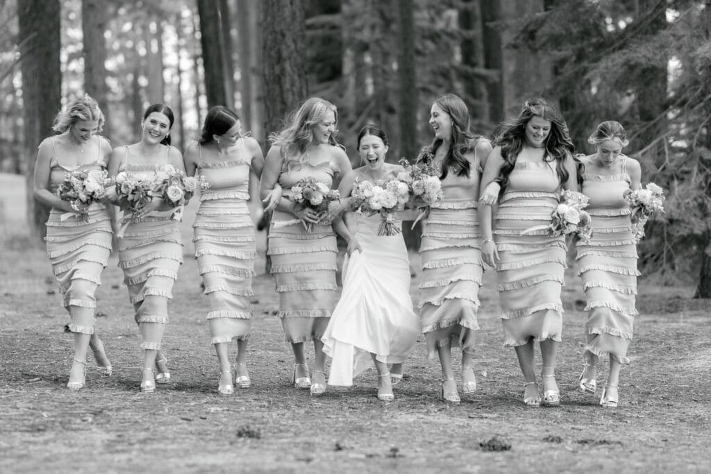 Bride and bridesmaids walking together through the pine forest at Edgewood Tahoe before the ceremony.