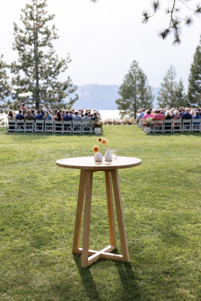 Outdoor wedding ceremony at Edgewood Tahoe featuring rows of guests seated on a manicured lawn overlooking Lake Tahoe.