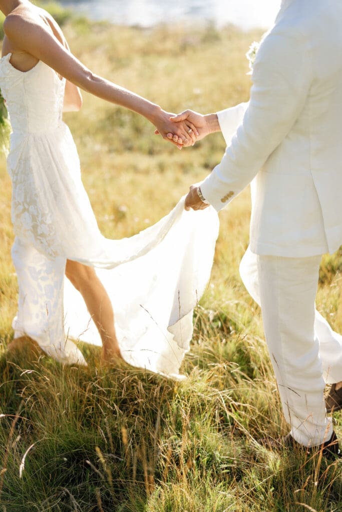 Bride and groom walking through the tall grass during an Everline Resort wedding day timeline in Lake Tahoe.