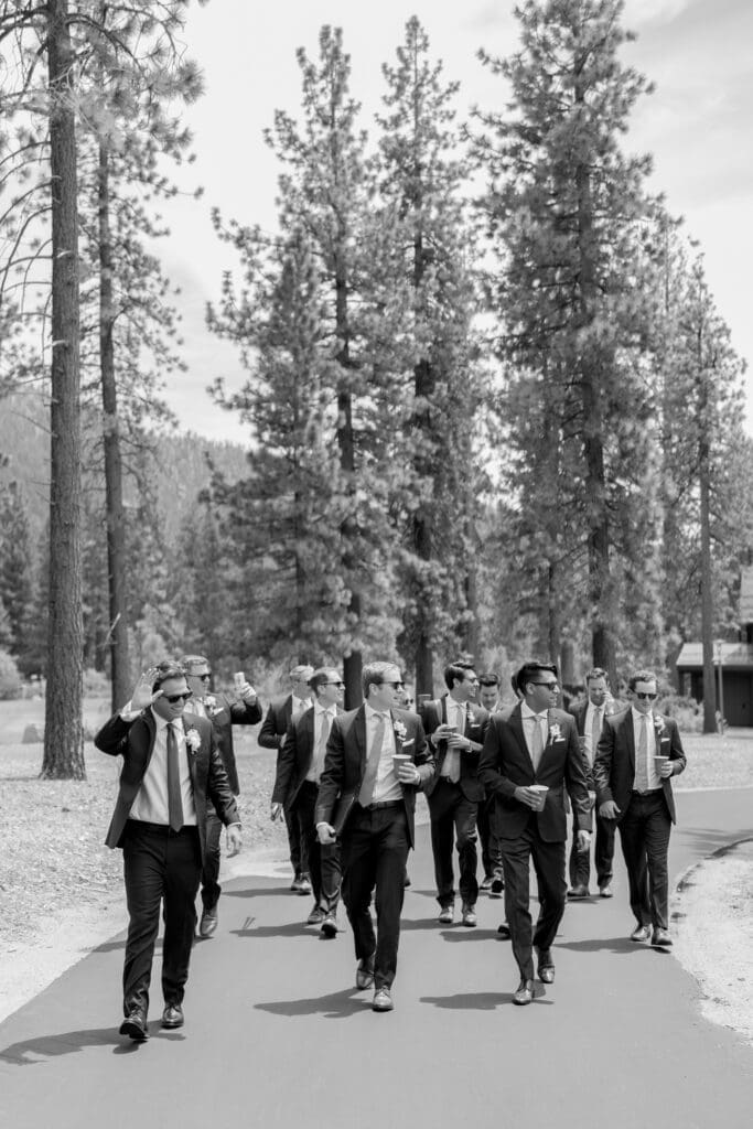 Wedding party walking beneath the pine trees during an Edgewood Tahoe wedding day timeline near the golf course.