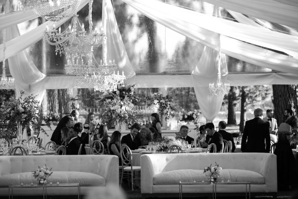 Elegant wedding reception tent at Edgewood Tahoe with crystal chandeliers, draped fabric, and luxury lounge seating.