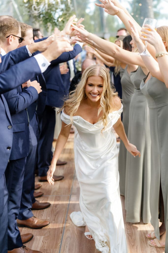 Bride entering the reception at Edgewood Resort surrounded by wedding guests.