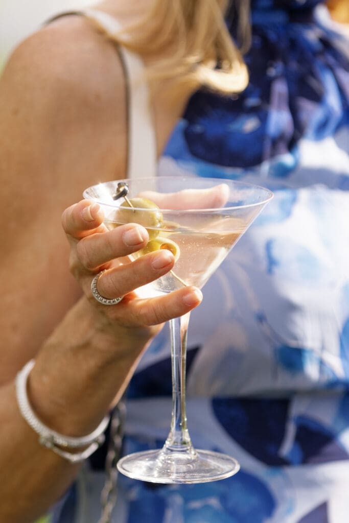 Wedding guest holding martini during cocktail hour at Edgewood Tahoe wedding reception