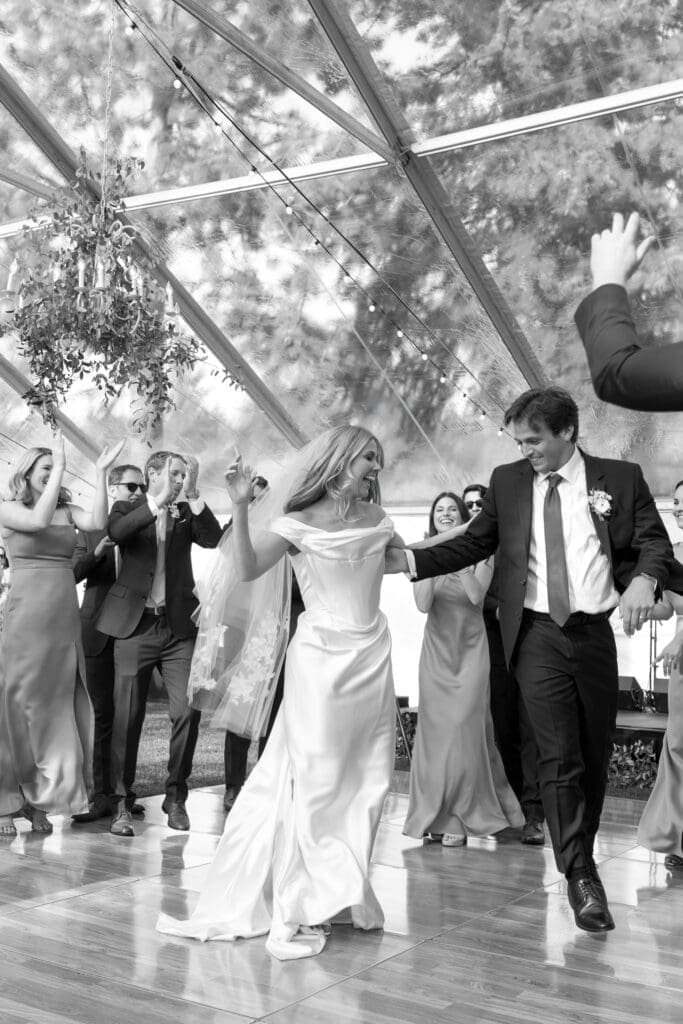 Bride and groom dancing during an Edgewood Tahoe wedding reception beneath a clear top tent