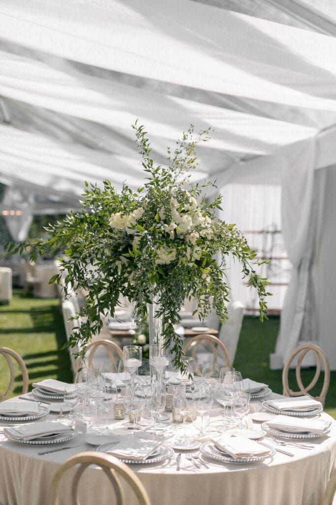 Elegant tented reception table design at Edgewood Tahoe 17th Green with tall floral centerpiece and natural light