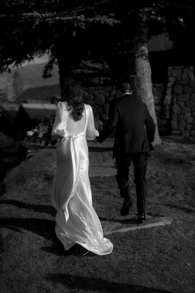 Bride and groom walking toward the Edgewood Tahoe North Room at sunset