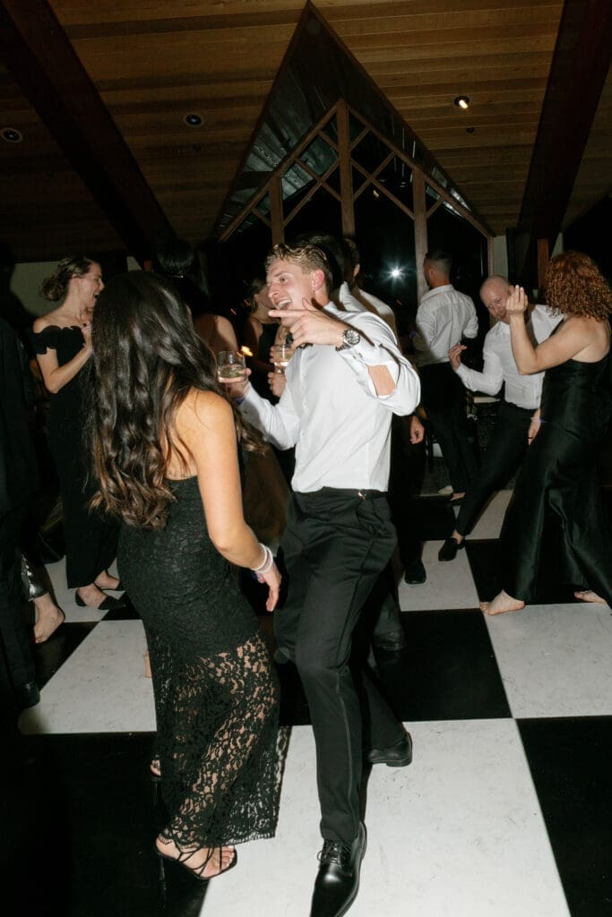 Guests gathering around the checkered dance floor inside the Edgewood Resort Lake Club.