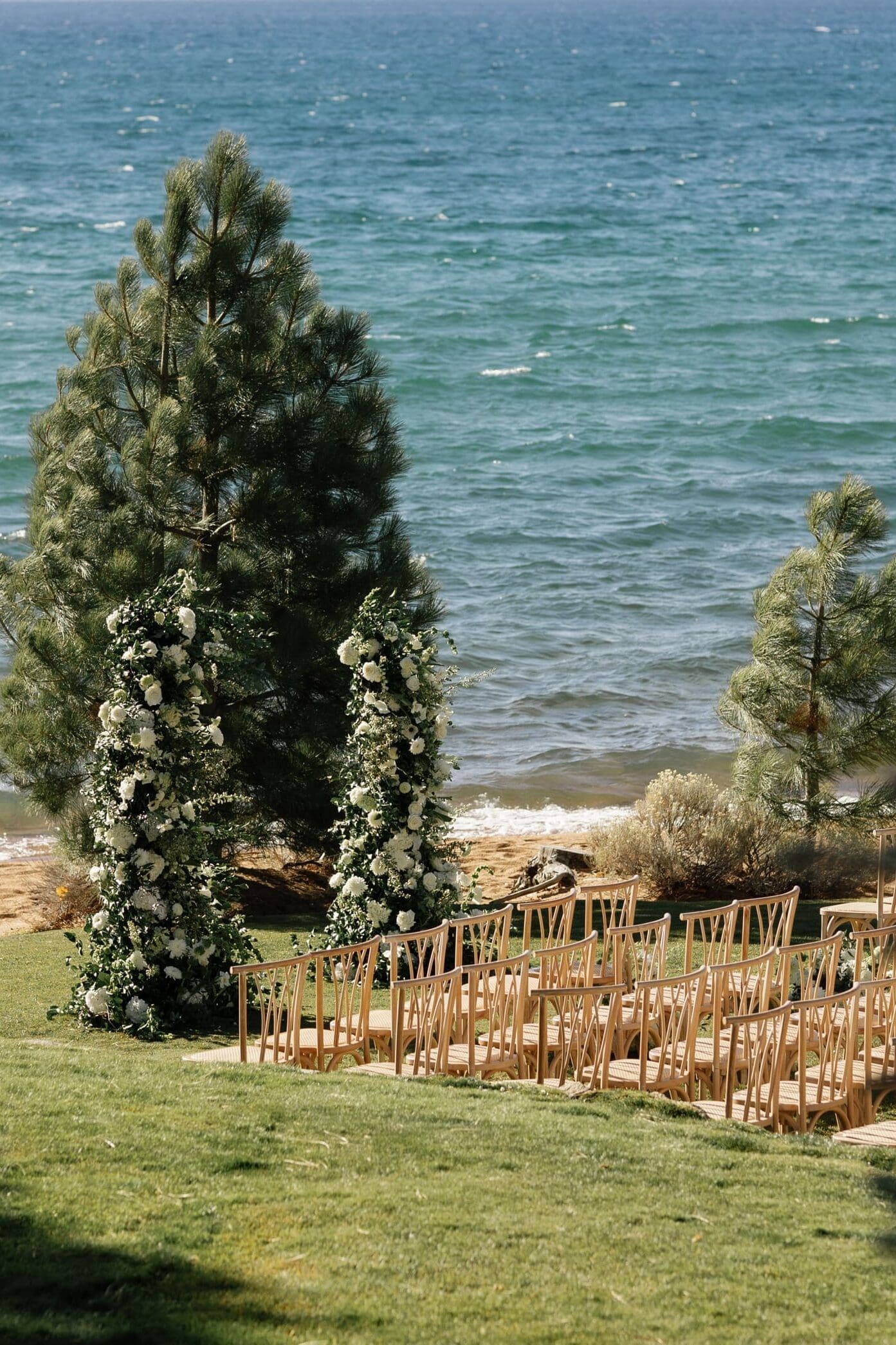Lakefront wedding ceremony at Edgewood Tahoe with floral arch overlooking Lake Tahoe