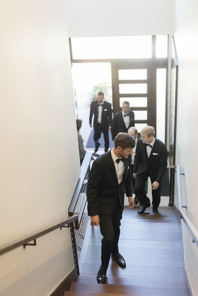 Groom and groomsmen walking down the staircase inside Edgewood Resort before the ceremony.