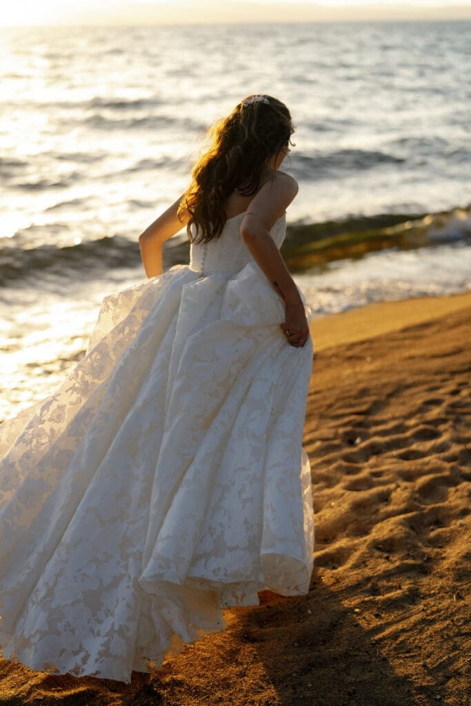 Bride running along shore during golden hour portraits at Edgewood Tahoe’s North Room.