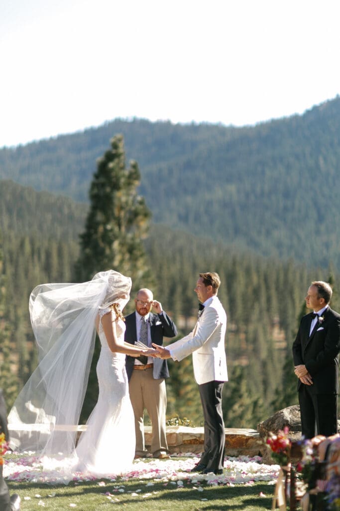Bride and groom exchanging vows during outdoor Martis Camp wedding ceremony overlooking the Sierra mountains