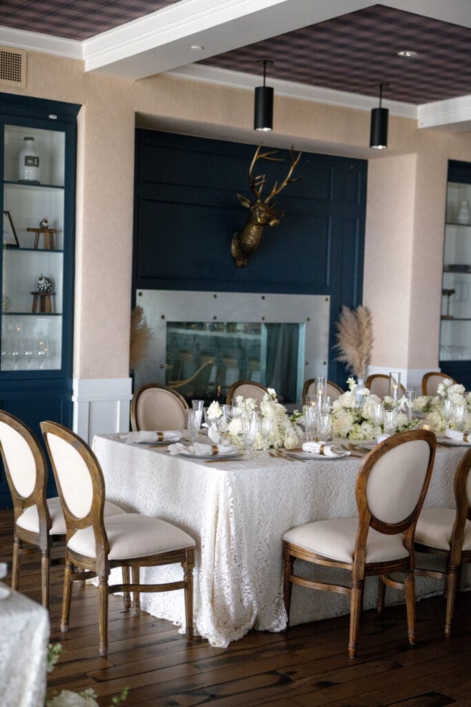 Luxury reception setup inside Tahoe Beach Club with neutral floral tablescapes, wood floors, and modern lakefront interior design