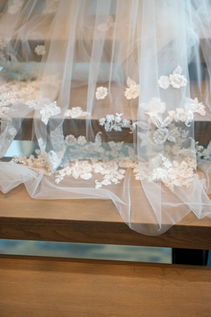 Bridal veil detail with floral embroidery draped across modern wood table at Tahoe Beach Club