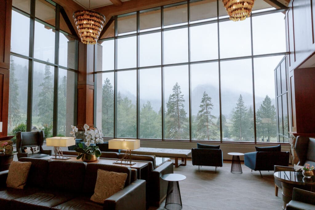 Elegant Everline Resort & Spa lounge featuring floor-to-ceiling windows, contemporary seating, and views of the surrounding pine forest.