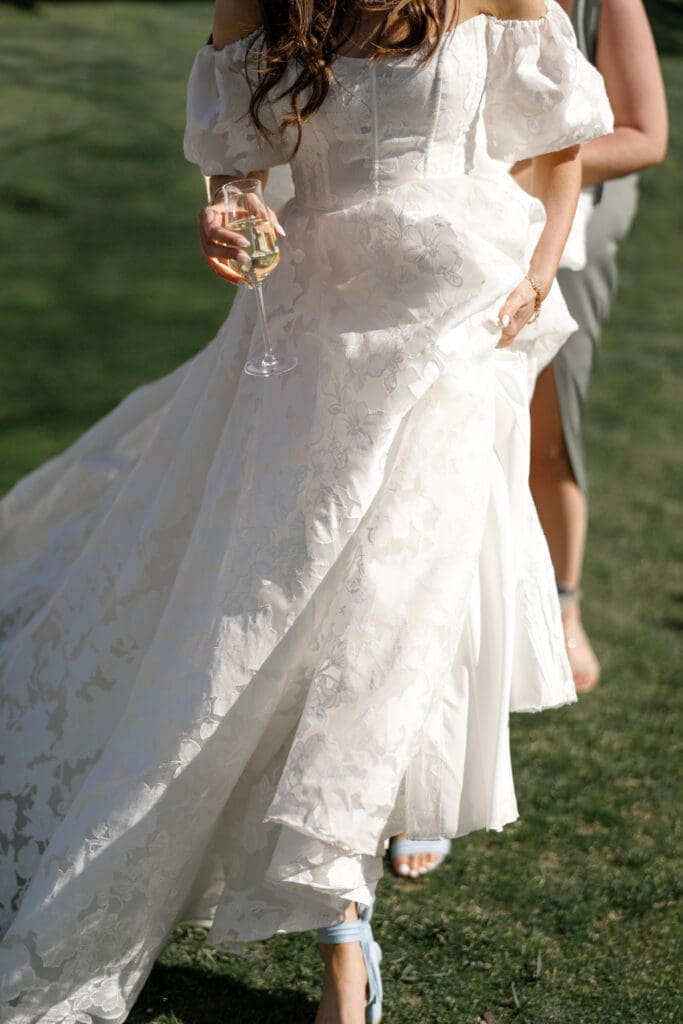 Bride walking across the lawn at Edgewood Tahoe during cocktail hour.