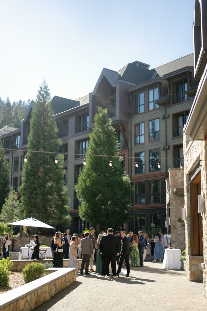 Exterior of The Ritz-Carlton Lake Tahoe wedding venue with mountain lodge architecture and guests gathered in the courtyard.