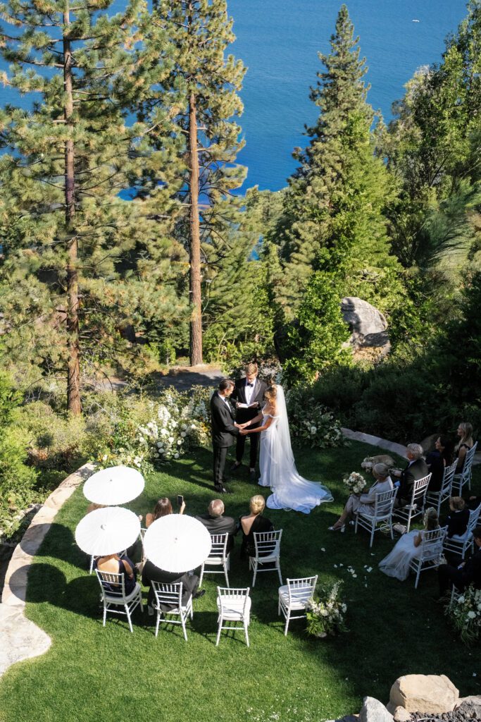 Intimate private estate wedding in Lake Tahoe featuring an outdoor ceremony on a manicured lawn surrounded by pine trees and lake views.